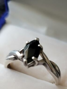 This is a vintage Avon sterling silver ring featuring a black marquise-cut stone